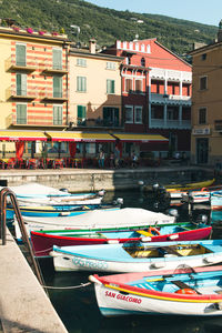 Boats moored on canal by buildings in city