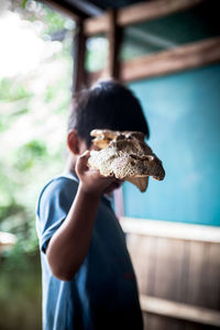 Close-up of boy holding animal skull