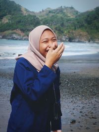 Portrait of young woman standing on beach