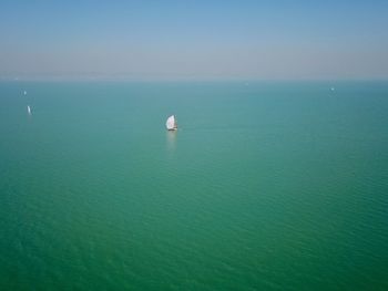 Sailboat in sea against sky