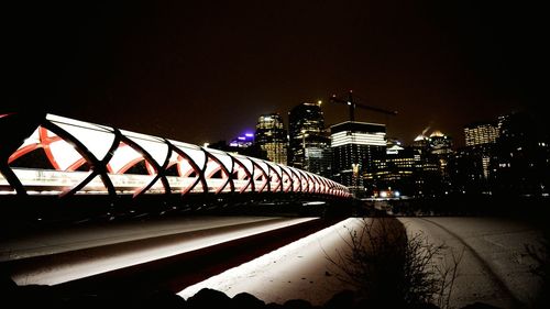 Illuminated bridge against sky at night