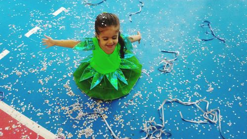 High angle view of happy girl wearing costume enjoying in confetti