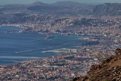 High angle view of cityscape by sea against sky