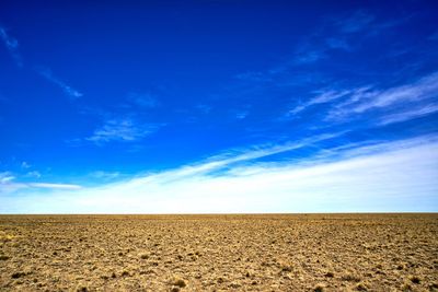 Scenic view of desert against blue sky