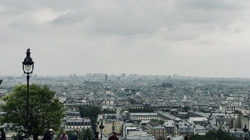 Buildings in city against cloudy sky