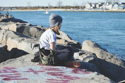 Full length of woman sitting on rocks