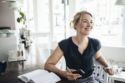 Smiling woman accounting in a cafe