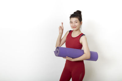 Portrait of smiling young woman against white background