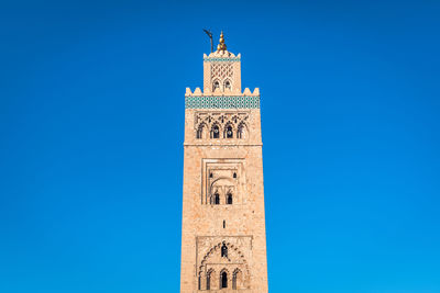 Low angle view of clock tower against blue sky