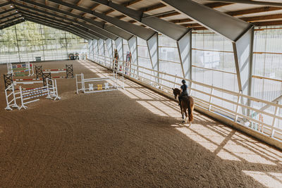 View of horse rider using indoor riding paddock