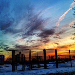 Scenic view of snow covered field against cloudy sky