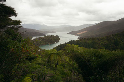 Scenic view of river and mountains against sky