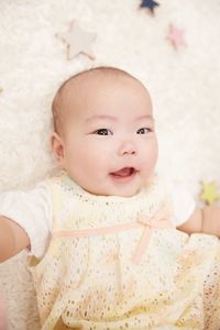 Cute baby boy lying on bed at home