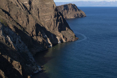Rock formations by sea against sky