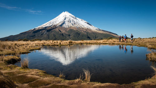 Scenic view of lake and mountains against blue sky