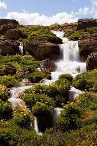 Scenic view of waterfall against sky