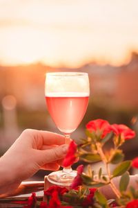 Close-up of hand holding red wine in glass