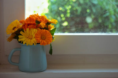 Close-up of flowers in vase on window 