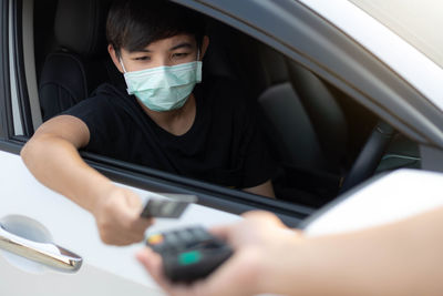 Portrait of young man sitting in car