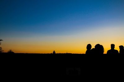 Silhouette men against clear sky during sunset