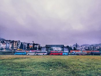 Train on field against sky in city