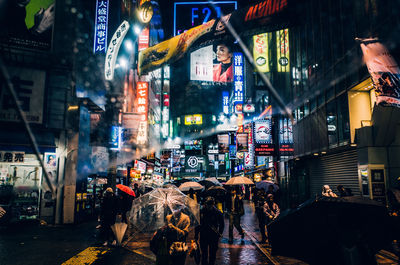 People on illuminated street at night