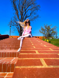 Rear view of woman sitting on roof