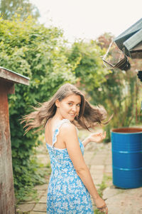 Portrait of smiling girl standing against plants
