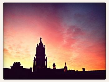 Silhouette built structures against dramatic sky