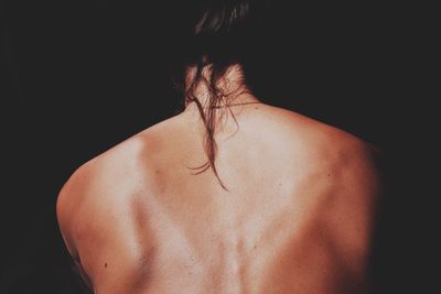 Close-up of woman over black background