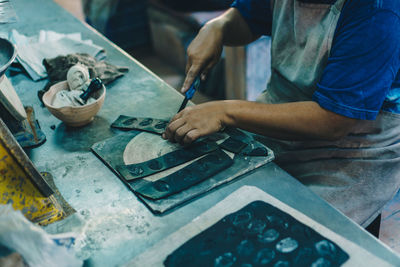 Midsection of craftsperson working at workshop