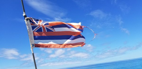 Low angle view of flags against blue sky