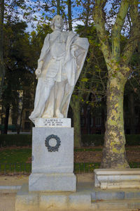 Statue against trees at cemetery