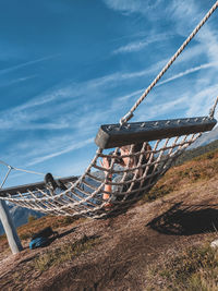 Metallic structure on rope against sky