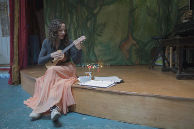 Young female musician practicing the ukulele