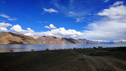 Scenic view of lake and mountains against blue sky