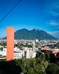 Buildings in city against blue sky