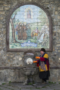 Rear view of woman standing against window