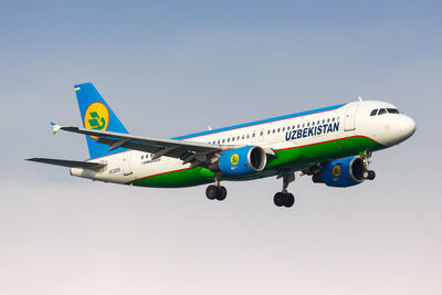 Low angle view of airplane against clear blue sky