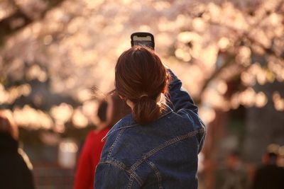 Rear view of woman photographing outdoors