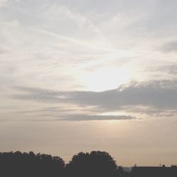 Silhouette of trees against cloudy sky