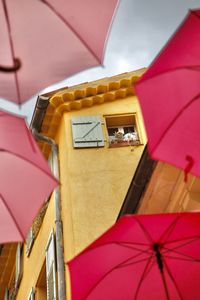 Low angle view of multi colored umbrella against building