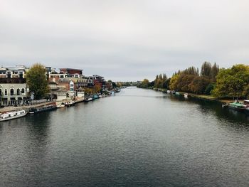 River amidst city against sky