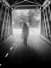 Rear view of woman standing on wooden floor