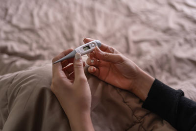 Close-up of woman using mobile phone on bed