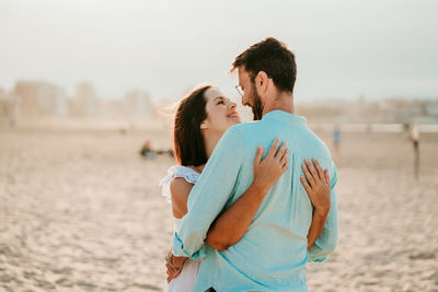 Couple embracing while standing on beach