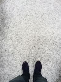 Low section of man standing in snow