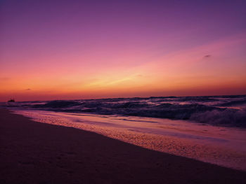 Scenic view of beach against romantic sky at sunset