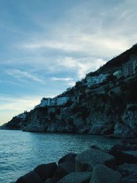 Rock formations by sea against sky