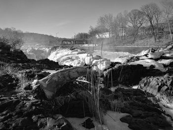 Scenic view of river by trees during winter